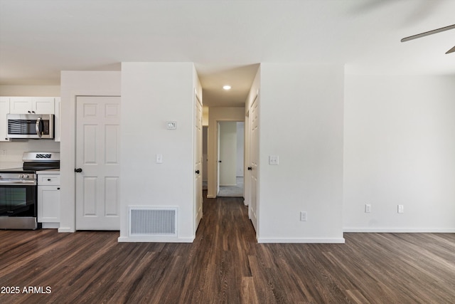 kitchen featuring ceiling fan, dark wood-type flooring, white cabinets, and stainless steel appliances