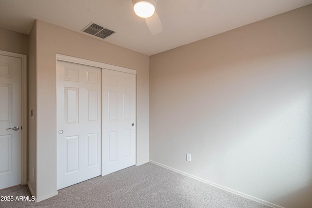 unfurnished bedroom with baseboards, visible vents, a ceiling fan, carpet flooring, and a closet