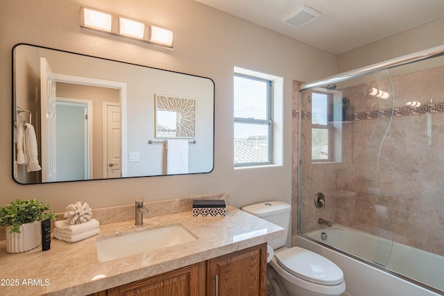 full bathroom with toilet, enclosed tub / shower combo, visible vents, and vanity