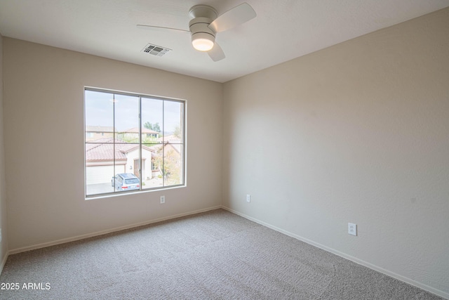 unfurnished room featuring carpet floors, visible vents, ceiling fan, and baseboards