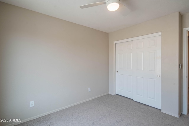 unfurnished bedroom with a ceiling fan, carpet, baseboards, and a closet