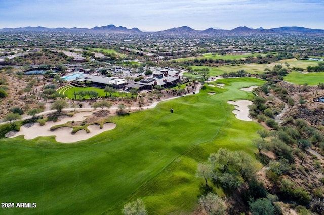 drone / aerial view with golf course view and a mountain view