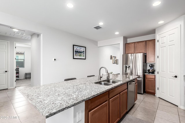 7910 S 33rd Ln, Laveen, AZ 85339 - kitchen featuring appliances with stainless steel finishes, light tile patterned flooring, an island with sink, recessed lighting, and light stone counters