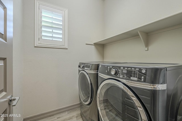 laundry area featuring washing machine and dryer and light hardwood / wood-style floors