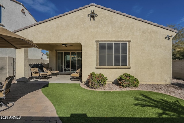 rear view of property with a yard, a patio, and ceiling fan