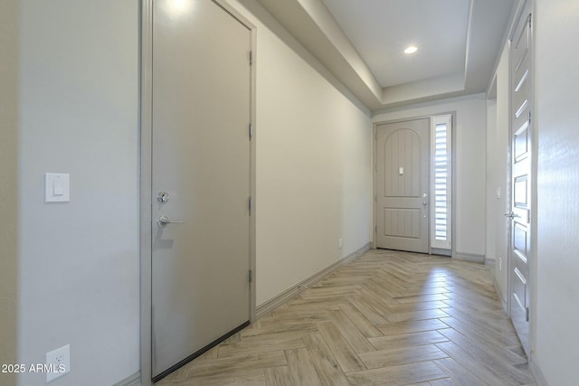 entrance foyer with light parquet floors and a raised ceiling