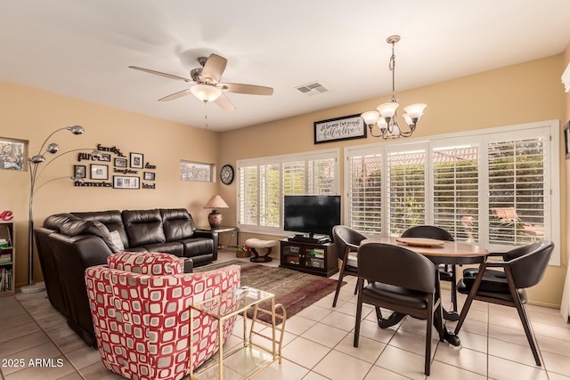 living room featuring ceiling fan with notable chandelier and light tile patterned floors