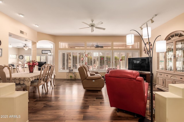 living room with dark wood-type flooring, ceiling fan, plenty of natural light, and track lighting