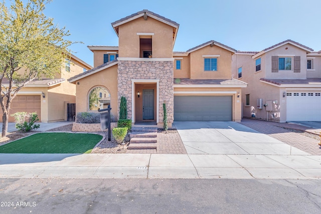 view of front of property with a tile roof, stucco siding, a garage, stone siding, and driveway