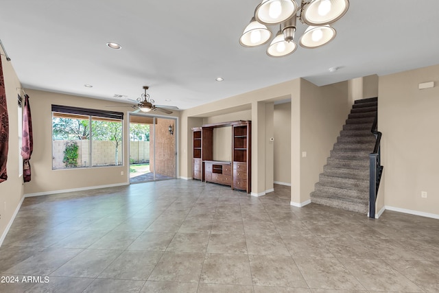 unfurnished living room with light tile patterned flooring, recessed lighting, ceiling fan with notable chandelier, baseboards, and stairway