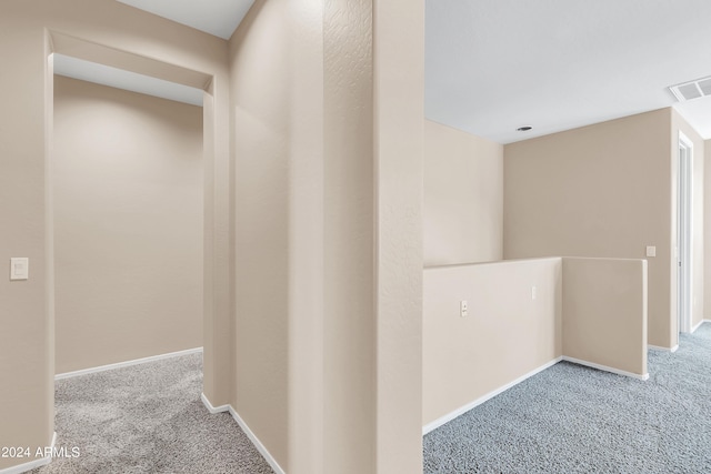 hall featuring carpet floors, baseboards, and visible vents