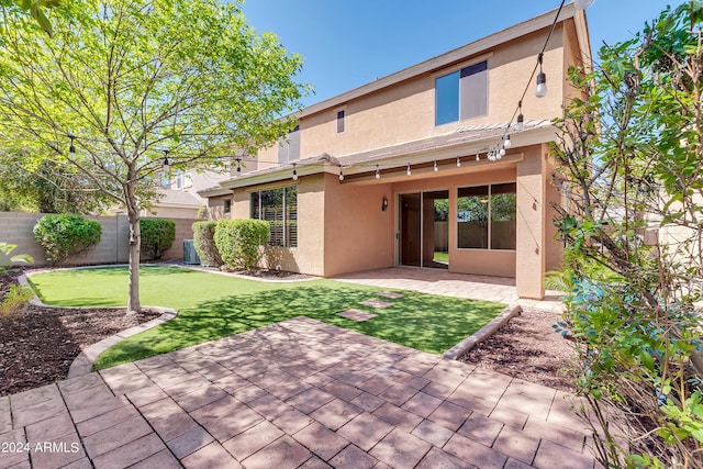 back of property featuring a patio, central AC, fence, a lawn, and stucco siding