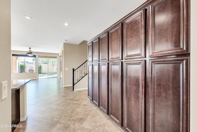 corridor with stairs, recessed lighting, baseboards, and light tile patterned floors