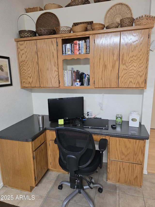 home office with light tile patterned floors and built in desk