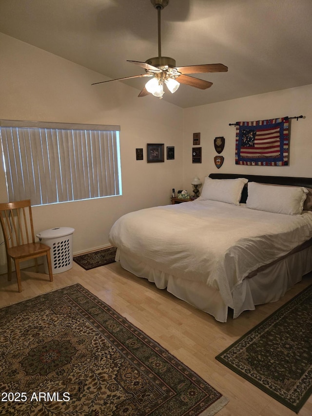 bedroom featuring a ceiling fan, lofted ceiling, and wood finished floors