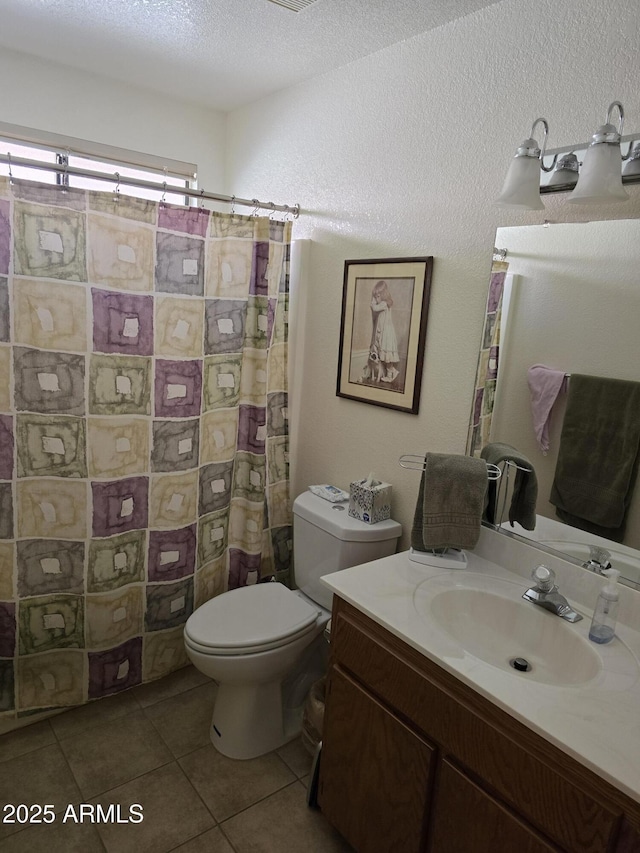 full bathroom featuring toilet, a shower with curtain, tile patterned flooring, a textured ceiling, and vanity