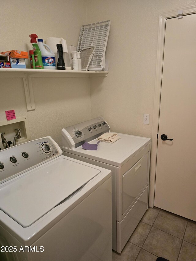 clothes washing area featuring laundry area, light tile patterned floors, and independent washer and dryer