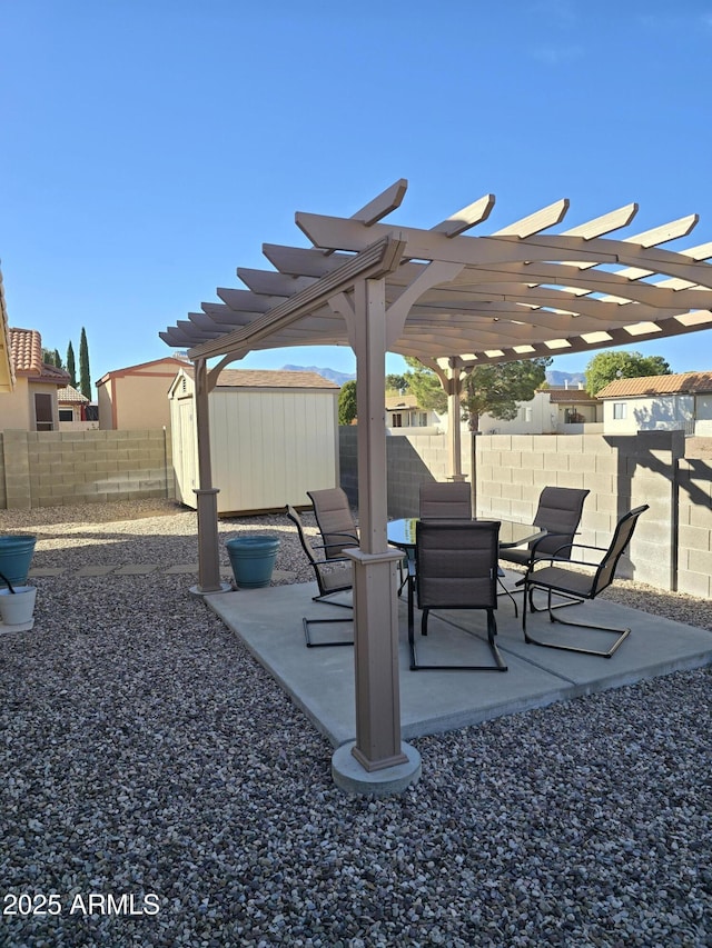 view of patio featuring a storage unit, an outdoor structure, a fenced backyard, and a pergola