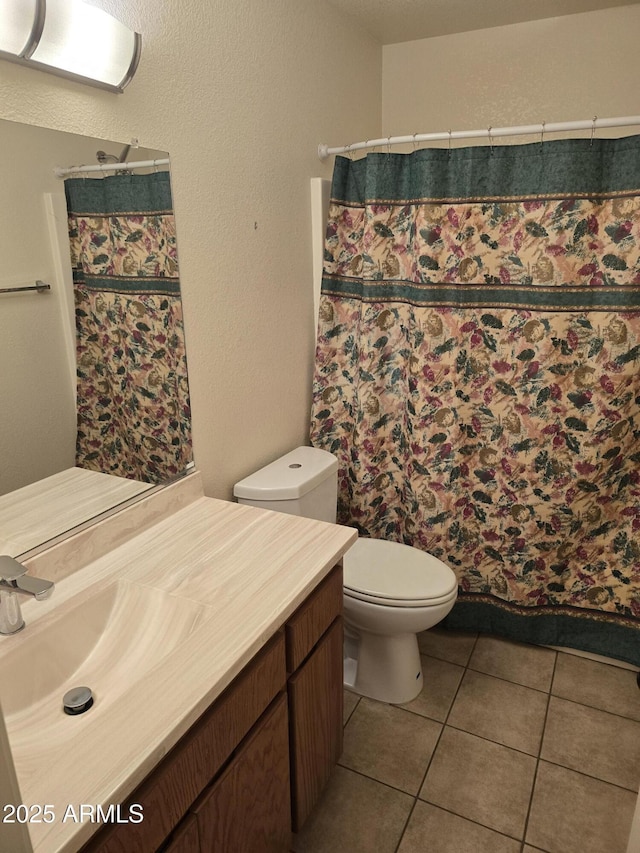 full bath featuring a shower with shower curtain, toilet, vanity, and tile patterned floors