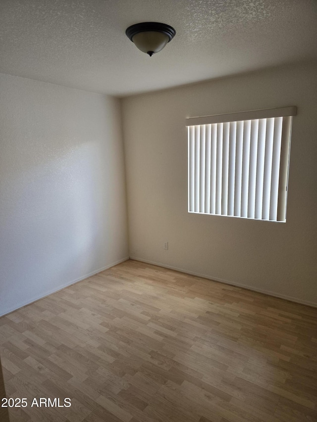 unfurnished room featuring wood finished floors and a textured ceiling