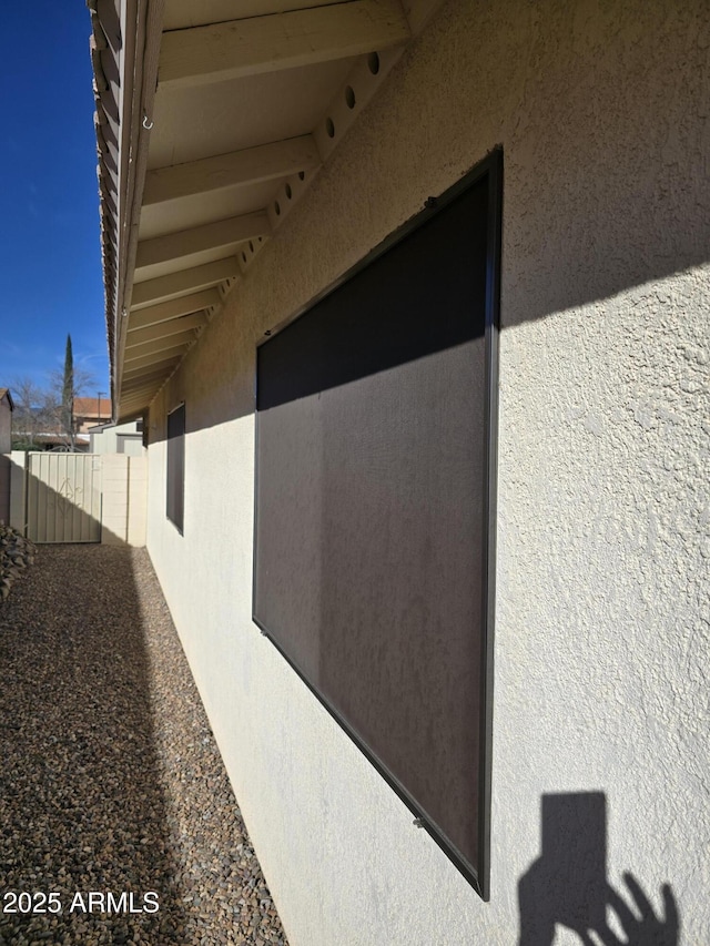 view of property exterior with fence and stucco siding