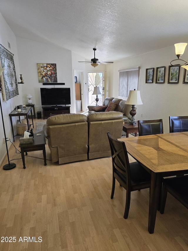 dining room with a textured ceiling, ceiling fan, and light wood-style floors