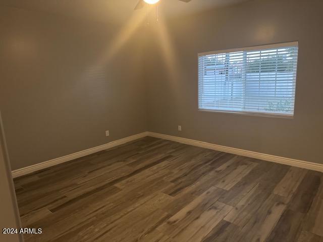 empty room featuring ceiling fan and dark wood-type flooring