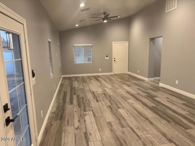 unfurnished room featuring ceiling fan, wood-type flooring, and high vaulted ceiling