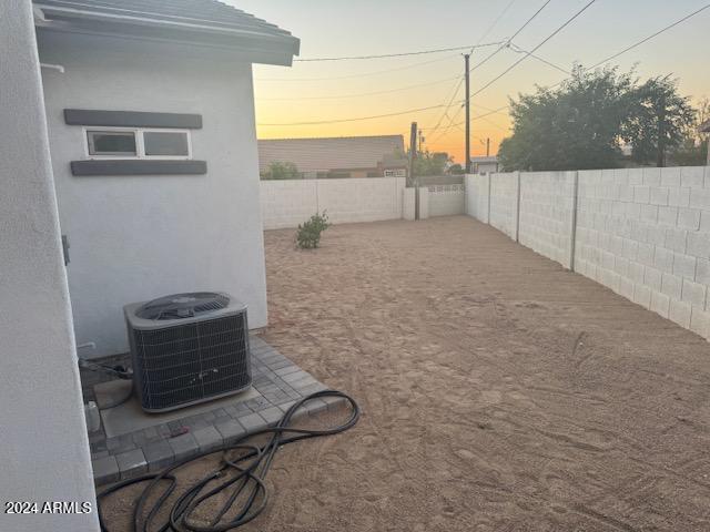 yard at dusk with central AC unit