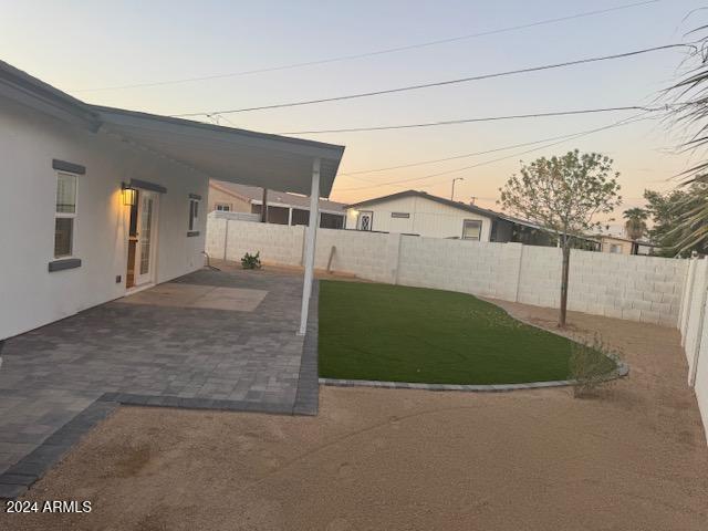 yard at dusk featuring a patio area