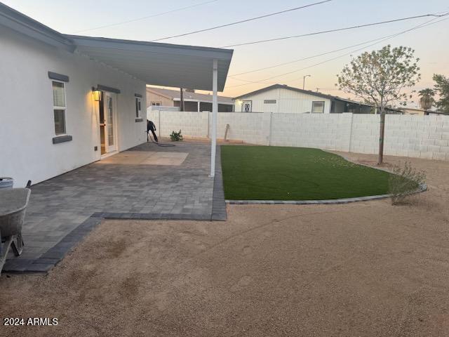 yard at dusk with a patio area