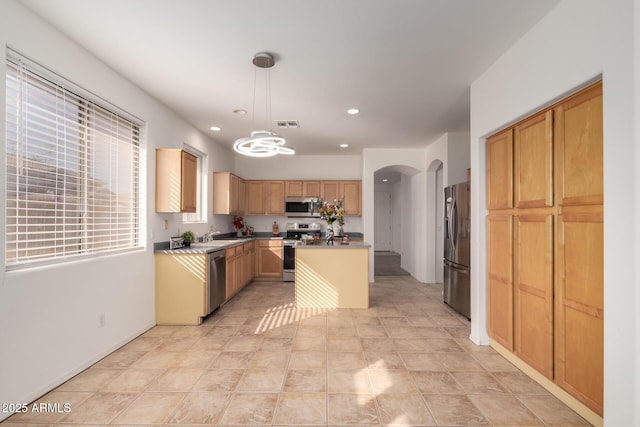 kitchen with decorative light fixtures, a kitchen island, and appliances with stainless steel finishes