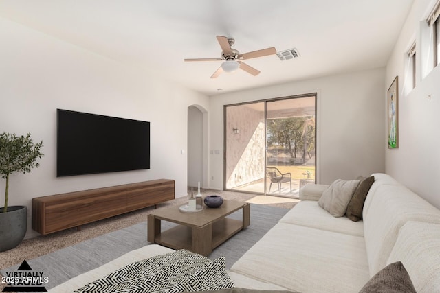 carpeted living room with ceiling fan