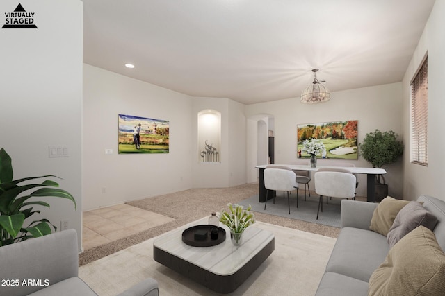 carpeted living room featuring a chandelier