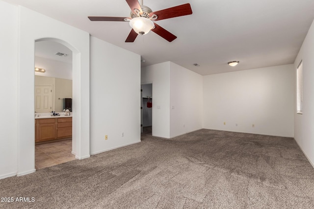 carpeted spare room featuring ceiling fan