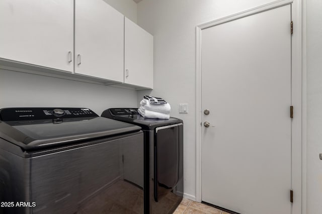 clothes washing area with cabinets, washer and dryer, and light tile patterned flooring