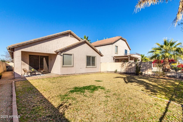 back of property featuring a lawn and a patio area