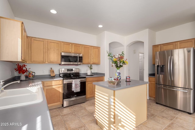 kitchen featuring light tile patterned flooring, appliances with stainless steel finishes, a center island, and sink