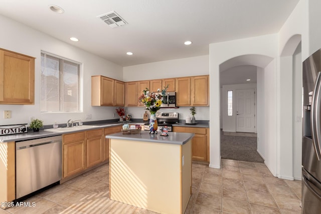 kitchen with sink, a kitchen island, and appliances with stainless steel finishes