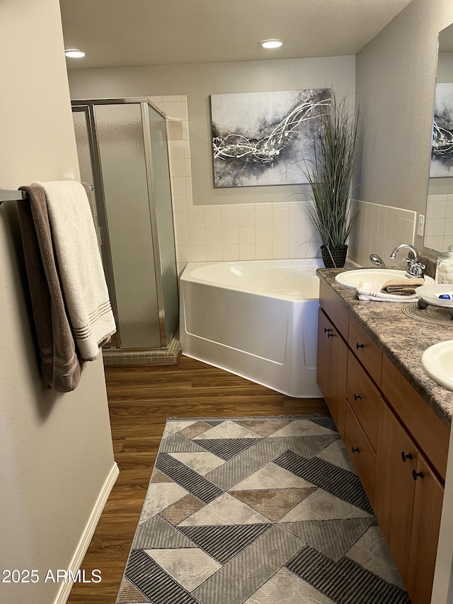 14250 W Wigwam Blvd Unit 812, Litchfield Park, AZ 85340 - bathroom with a sink, double vanity, a stall shower, a garden tub, and wood finished floors