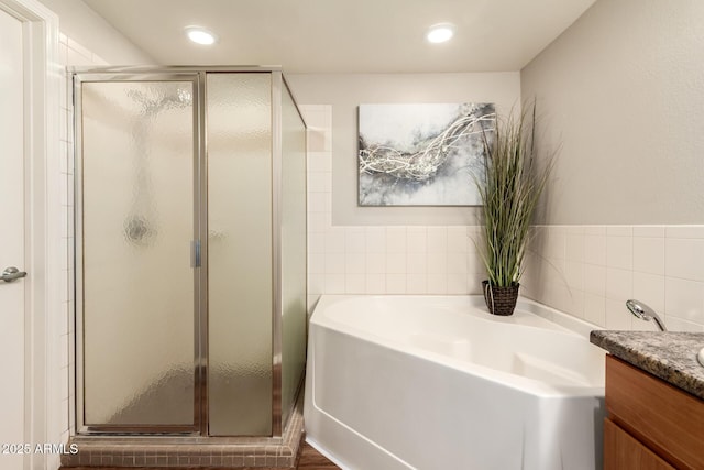 14250 W Wigwam Blvd Unit 812, Litchfield Park, AZ 85340 - full bathroom with vanity, recessed lighting, a shower stall, tile walls, and a garden tub