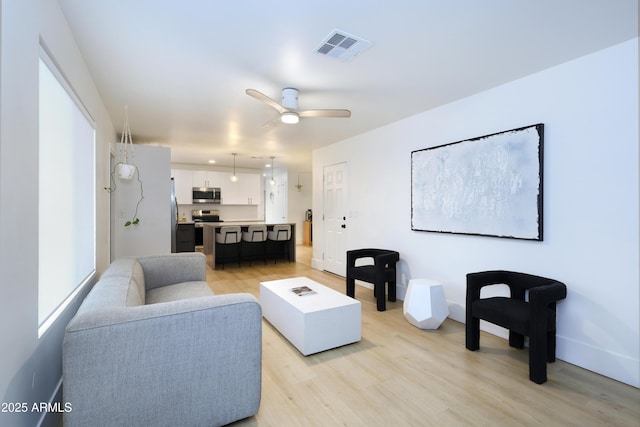 living room featuring ceiling fan and light wood-type flooring