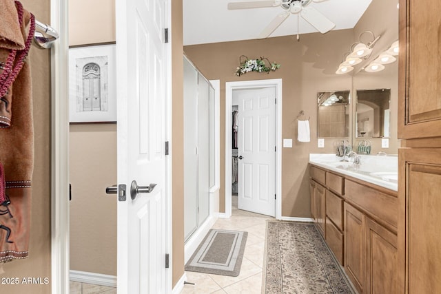 bathroom with double vanity, baseboards, a ceiling fan, tile patterned floors, and a sink