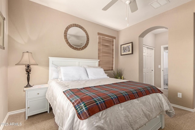 bedroom featuring visible vents, arched walkways, a ceiling fan, baseboards, and light colored carpet