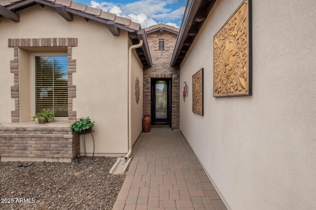 entrance to property with stone siding and stucco siding