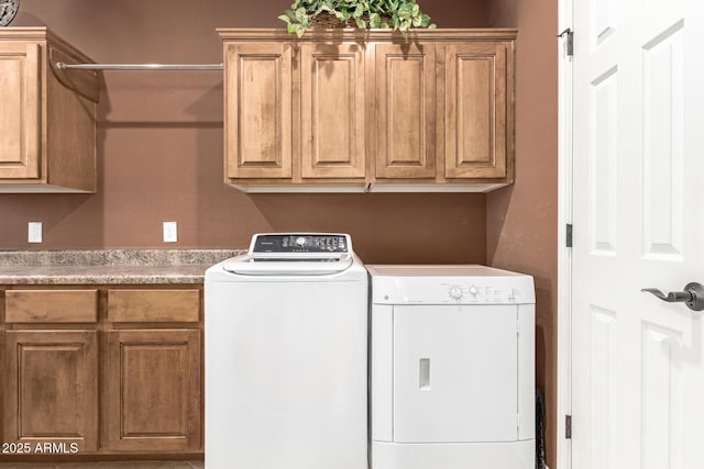 laundry area with separate washer and dryer and cabinet space