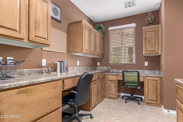 office featuring visible vents, built in desk, and light tile patterned floors