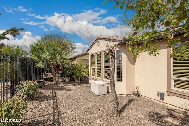 back of house featuring fence and stucco siding