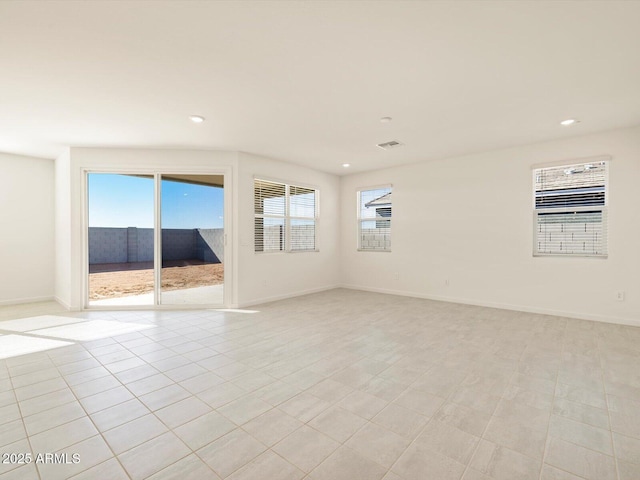 unfurnished room with light tile patterned floors and a wealth of natural light