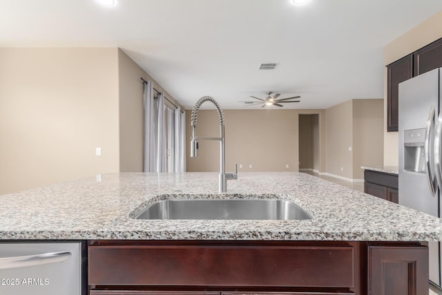 kitchen with ceiling fan, a sink, visible vents, dark brown cabinets, and appliances with stainless steel finishes